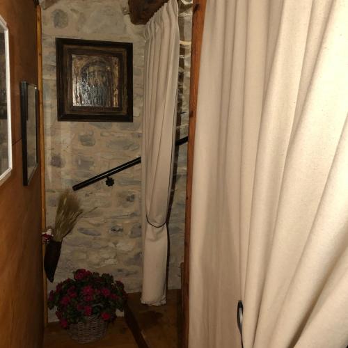 a curtain in a room with a stone wall at CASA ANGELA Stayerat a SEGUSINO Valdobbiadene in Segusino
