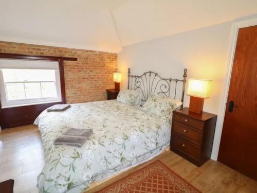 a bedroom with a large bed and a brick wall at 6 bed Cozy Victorian Cottage in Balnamore