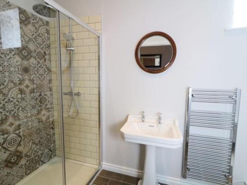 a bathroom with a sink and a shower at 6 bed Cozy Victorian Cottage in Balnamore