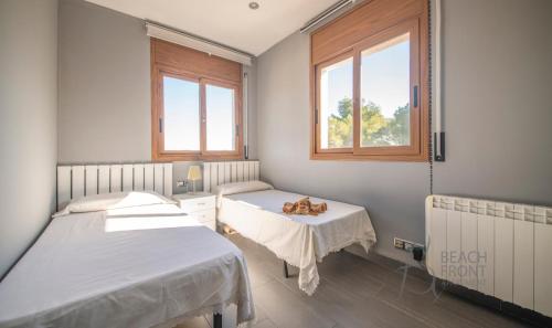 a hospital room with two beds and two windows at R138 Casa Jessy con gran jardin, piscina y AC in Calafell