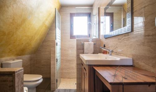 a bathroom with a sink and a toilet and a mirror at R138 Casa Jessy con gran jardin, piscina y AC in Calafell