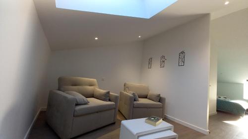 a living room with two chairs and a skylight at La Maison du Lac in Flavignac
