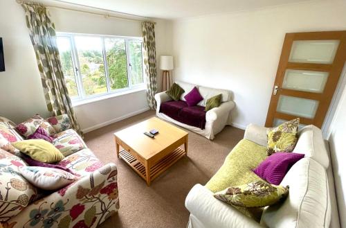 a living room with two couches and a table at Haytor Court, Haytor, Dartmoor in Haytor
