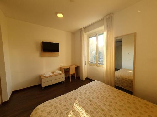 a hotel room with two beds and a window at Casa Immacolata in Verbania