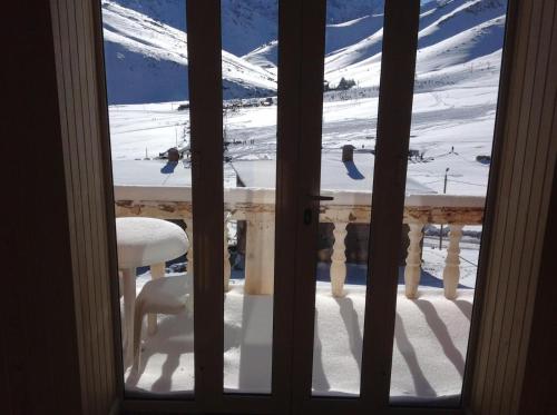 una vista desde una ventana de una mesa en la nieve en Chalet Savoyard Oukaimeden, en Oukaïmeden