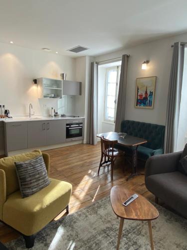 a living room with a couch and a table at Eco-Lodge City - Appart'Hôtel - VILLA CÔTÉ PLATEAU - Hyper Centre - 3 Étoiles Certifiées- in Angoulême