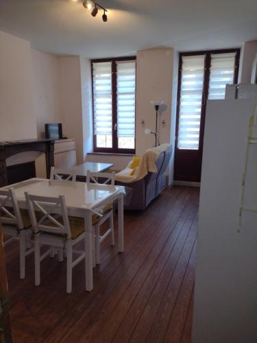 ein Wohnzimmer mit einem Tisch, Stühlen und einem Sofa in der Unterkunft Appartement 1er etage proche des Termes in Bourbonne-les-Bains
