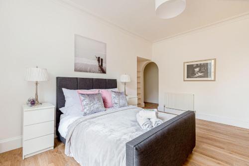 a bedroom with a large bed with a black headboard at Heart of Edinburgh City Centre 3 Bed Georgian Apt in Edinburgh