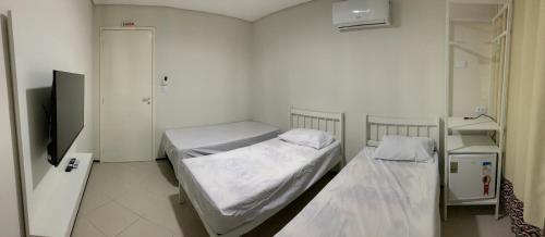 a hospital room with two beds and a tv at Senhor Hotel in Juazeiro do Norte