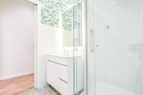 a white bathroom with a shower and a sink at MyHouseSpain - Estrena apartamento en el centro de Madrid - Atocha in Madrid
