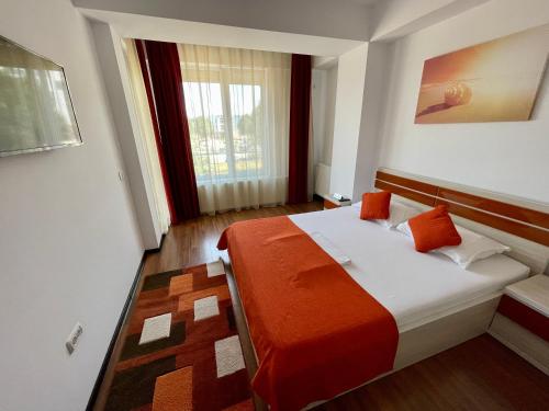 ママイアにあるAlcomar Apartment - Summerland Mamaiaのベッドルーム1室(オレンジ色の毛布付きのベッド1台付)