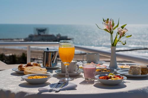 un tavolo con cibo e un bicchiere di succo d'arancia di Hotel Riviera a Mar del Plata