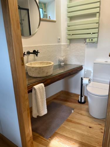 a bathroom with a sink and a toilet and a mirror at Casa da Linha in Amarante