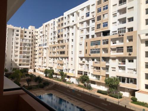 Elle offre une vue sur un grand immeuble depuis son balcon. dans l'établissement Appartement, à Agadir