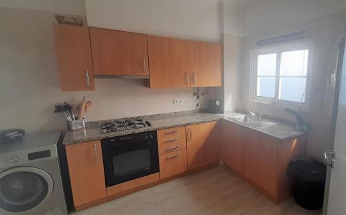 a kitchen with wooden cabinets and a sink and a dishwasher at Jay Paradise - Paraíso Jota in Santa Cruz