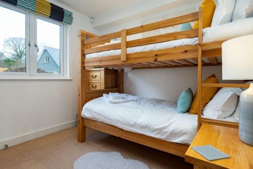 a bedroom with bunk beds and a desk at Trewhiddle Retreat V24 by Together Travel - Luxury 4-Bedroom Villa in St Austell