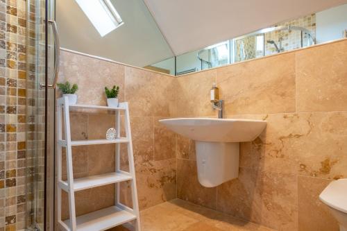 a bathroom with a sink and a mirror at Trewhiddle Retreat V24 by Together Travel - Luxury 4-Bedroom Villa in St Austell