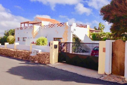 a white house with a gate and a fence at Casa Del Medio in Antigua