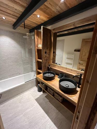 une salle de bain avec deux lavabos et une douche en verre dans l'établissement Le Garage à François, au Bourget-du-Lac