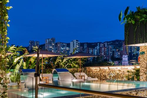 a restaurant with a view of the city at night at Elcielo Hotel Luxury Medellin in Medellín