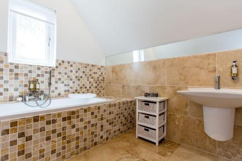 y baño con bañera y lavamanos. en Trewhiddle Villa 18 en St Austell