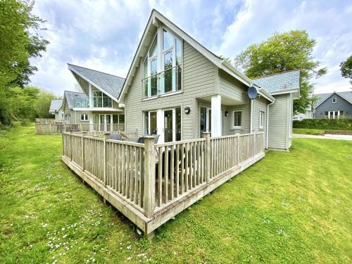 a house with a wooden fence in the yard at Trewhiddle Retreat V20 by Together Travel - Luxury 3-Bedroom Villa in St Austell