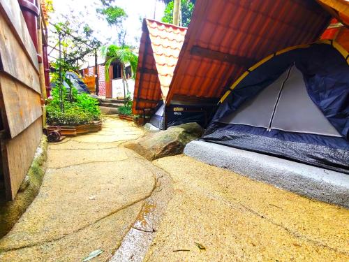 a tent sitting on the ground next to a building at Ready Camp e Suítes da Cachoeira in Abraão