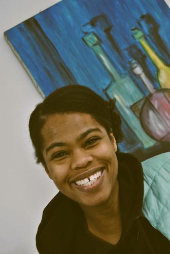 a woman is smiling in front of a painting at Balarm - Hostel and Bar in Palermo
