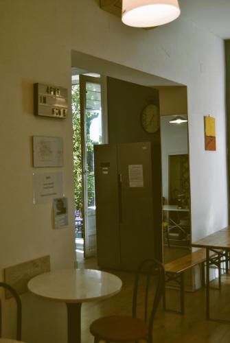 a room with tables and chairs and a clock on the wall at Balarm - Hostel and Bar in Palermo