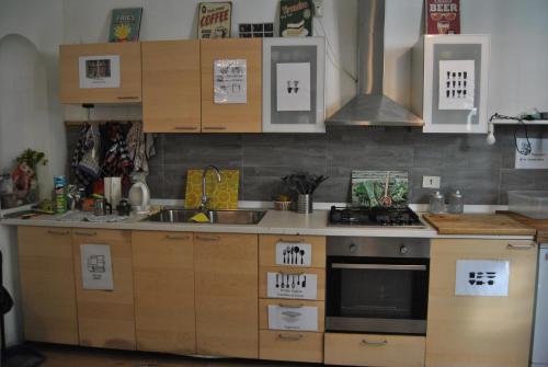 a kitchen with wooden cabinets and a stove top oven at Balarm - Hostel and Bar in Palermo