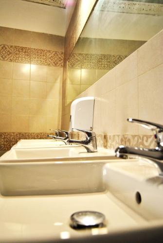 a bathroom with two sinks and a mirror at Balarm - Hostel and Bar in Palermo