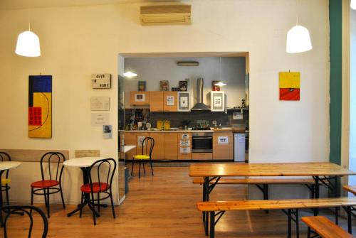 a room with tables and chairs and a kitchen at Balarm Hostel - Youth Hostel age limit 18-50 in Palermo