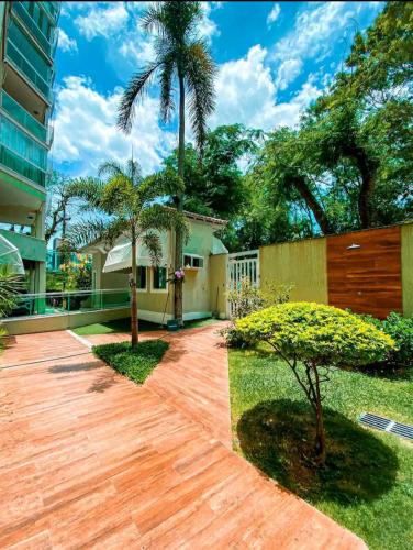 a house with a yard with a wooden driveway at Apart Hotel Alecrim Praia de Camboinhas com Marina pe na areia in Niterói