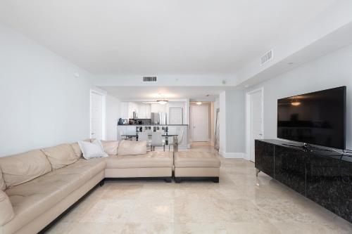 - un salon blanc avec un canapé et une télévision dans l'établissement Ritz Carlton Coconut Grove Luxury 2 BR Apt apts, à Miami