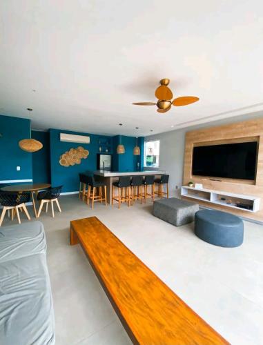 a living room with a couch and a tv at Apart Hotel Alecrim Praia de Camboinhas com Marina pe na areia in Niterói