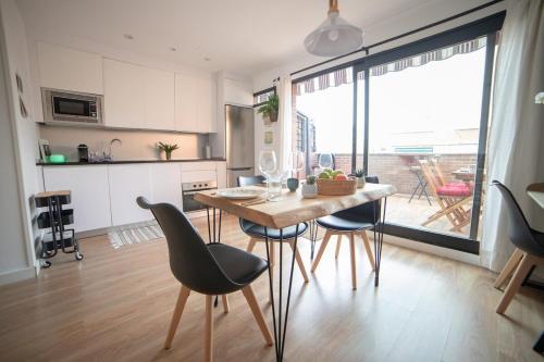 a kitchen and dining room with a table and chairs at MyHouseSpain - Precioso Ático con gran terraza centro Usera in Madrid