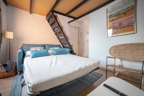 a bedroom with a bed and a spiral staircase at MyHouseSpain - Precioso Ático con gran terraza centro Usera in Madrid