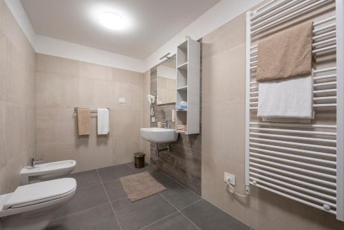 a bathroom with a white toilet and a sink at Agriturismo Le Tese in Colà di Lazise