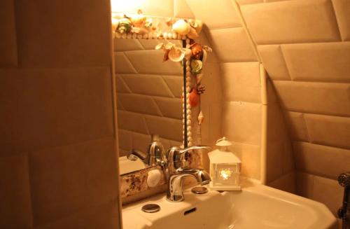 uma casa de banho com um lavatório, um espelho e um lavatório. em Gildò em Trani