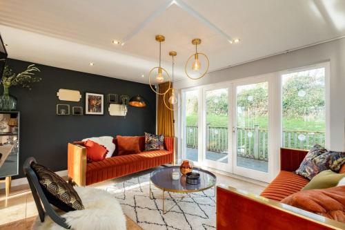 a living room with a couch and a table at Trewhiddle Retreat V5 by Together Travel - Luxury 4-Bedroom Villa in St Austell