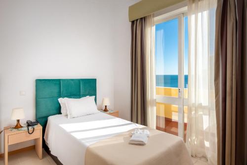 a hotel room with two beds and a view of the ocean at Hotel Santa Catarina Algarve in Portimão