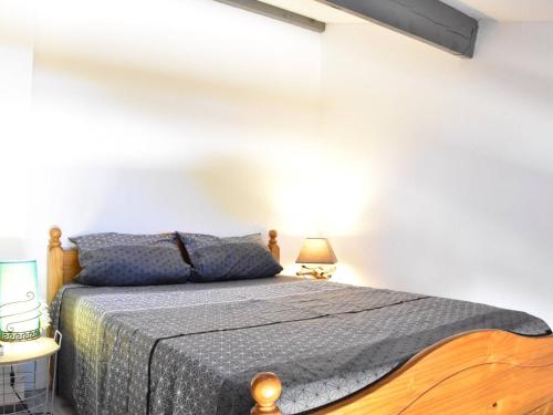 une chambre avec un lit et un mur blanc dans l'établissement Charmant Studio Mezzanine - Climatisé, Terrasse BBQ, Proche Plage et Commerces - 4 Couchages - FR-1-229-809, à Gruissan