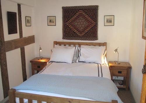 a bedroom with a large bed with two night tables at Corve Cottage Historic cottage in beautiful ludlow in Ludlow