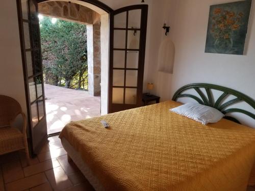 ein Schlafzimmer mit einem Bett und einer offenen Tür in der Unterkunft Villa La Louvière La Croix Valmer Golfe de Saint Tropez in La Croix-Valmer