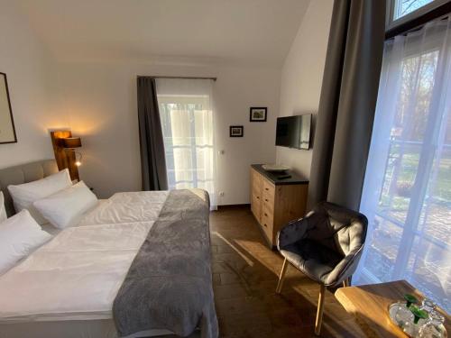 a bedroom with a bed and a chair and a window at Ferienhof Bludnik in Kaupen