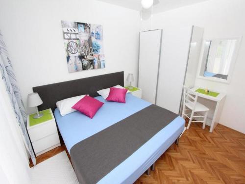 una camera con un letto con due cuscini rosa di Apartments Frane a Rovigno (Rovinj)