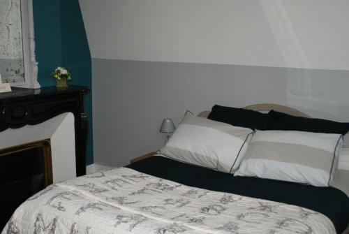 a bedroom with a bed with a white comforter at Les Hortensias in Clermont