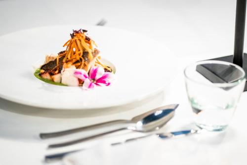 einen Teller mit Essen auf einem Tisch mit einem Löffel in der Unterkunft Diamma Resort Conference & Spa in Durrës