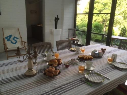 une table avec de la nourriture au-dessus dans l'établissement Les Hortensias, à Clermont