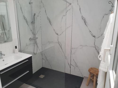 baño blanco con ducha y lavamanos en La Villa Juliette L'Etoile Filante en Biville-sur-Mer